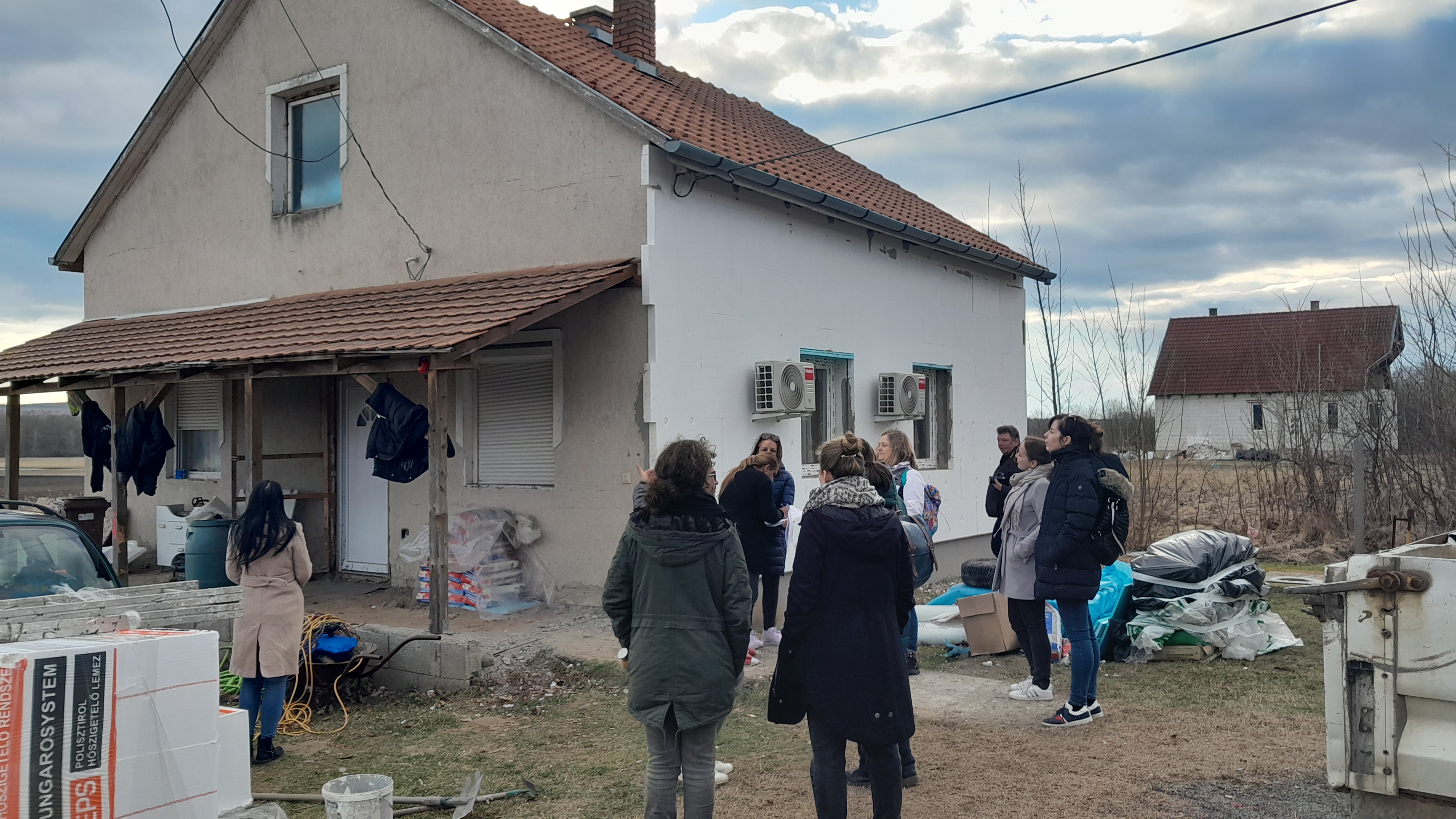 A group of people viweing a house from the outside