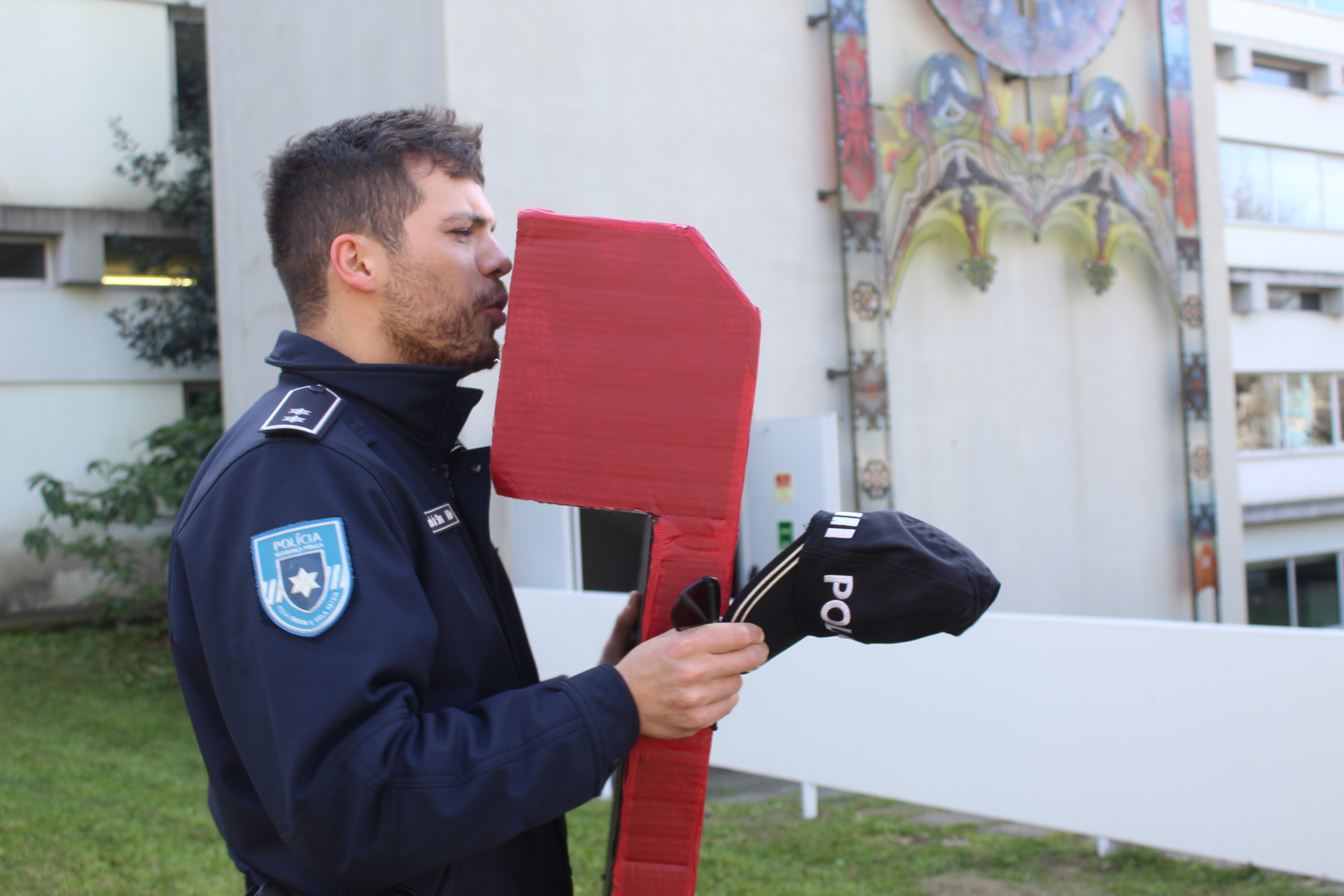 A police man is holding up a cardboard periscope