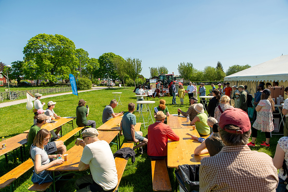 A group of people sitting around a table in a park