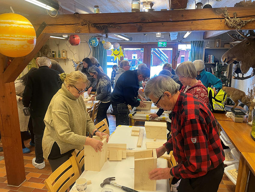 A group of people inside, seemingly signing up for something
