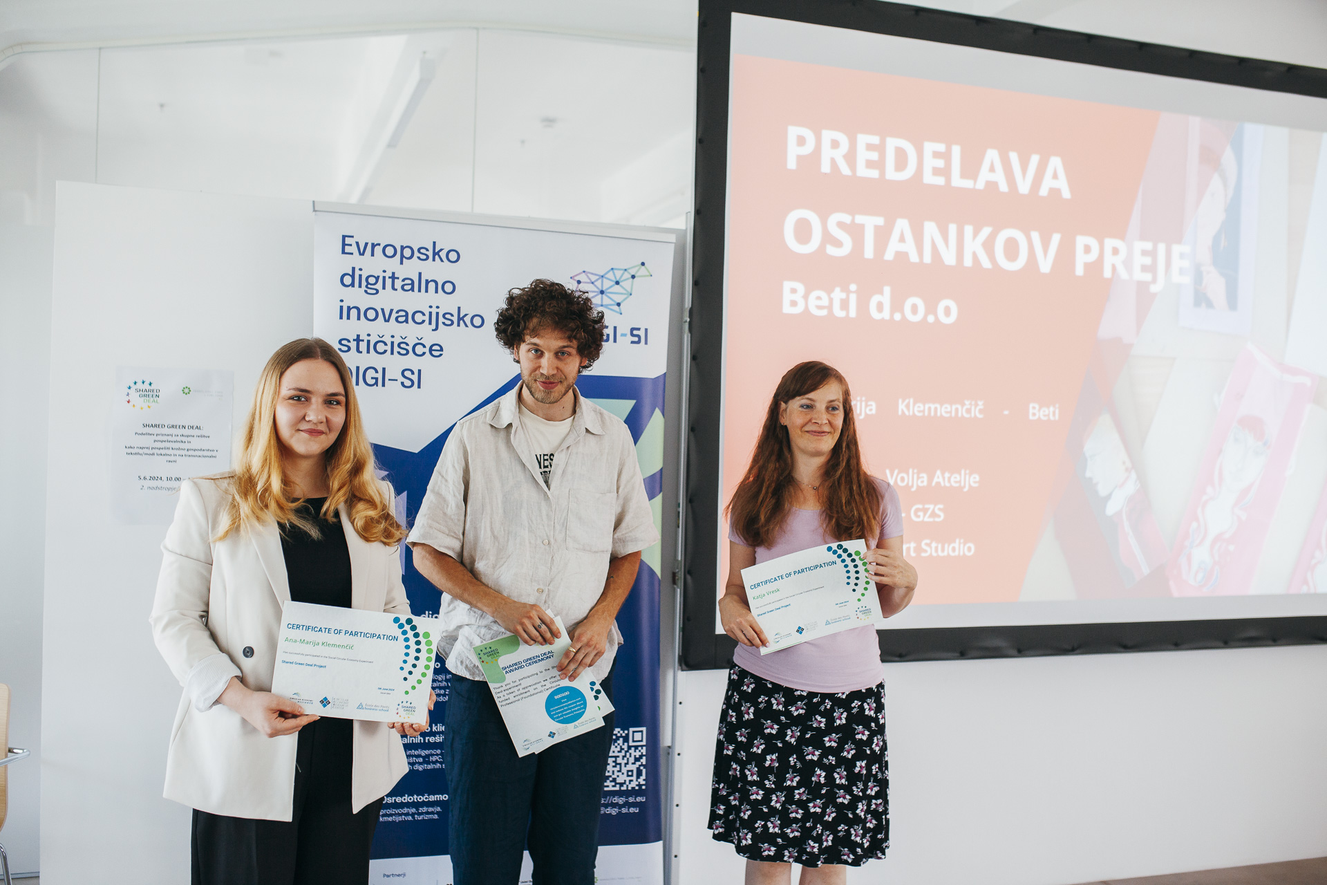 A woman and a man are receiving recognition in the form of a diploma