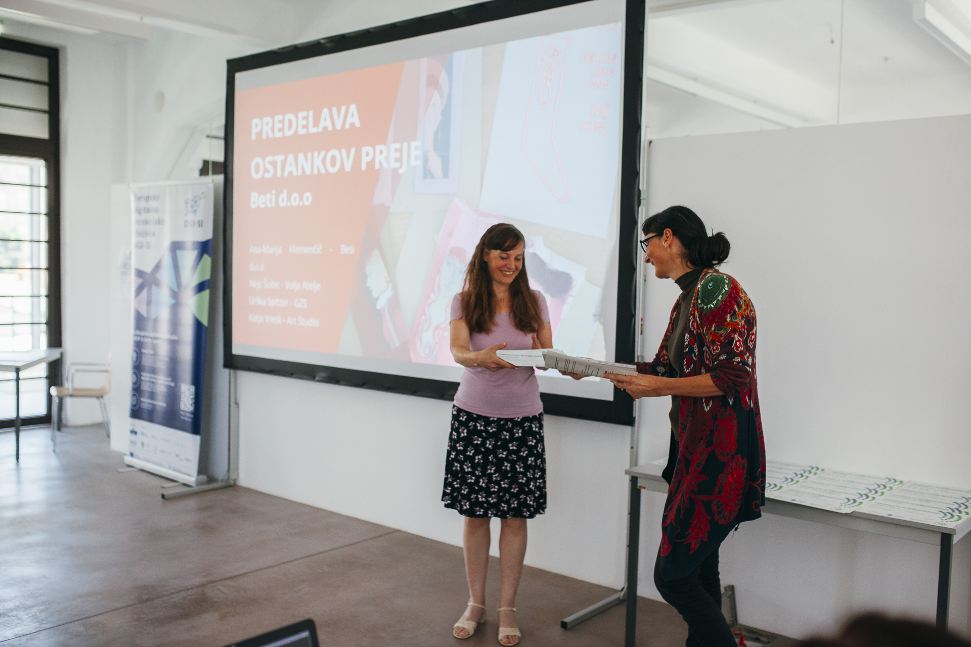 A woman is receiving recognition in the form of a diploma