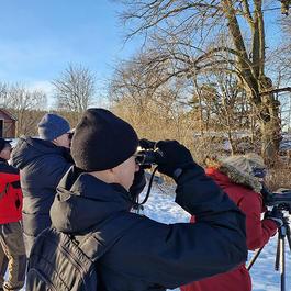 A group of people in the snow looking at something