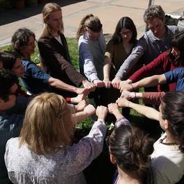 A group of people put their hands together in a circle