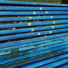 A photo of a bench, painted in European blue with stars in the miccle