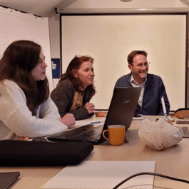 A photo from a workshop with people sitting around a table