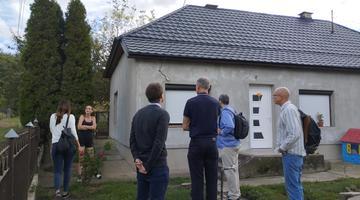 A photo of a group of people standing aorund a recently renovated house