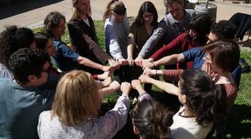 A group of people put their hands together in a circle