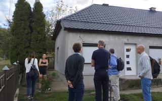 A photo of a group of people standing aorund a recently renovated house