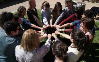 A group of people put their hands together in a circle