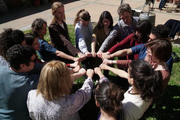 A group of people put their hands together in a circle