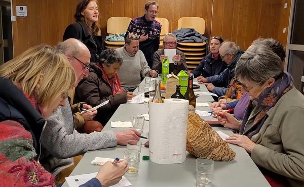 A photo of a group of people working around a table
