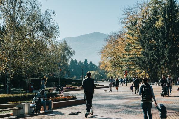 A public square or park in Sofia. A person is on a scooter,