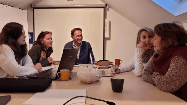 A photo from a workshop with people sitting around a table