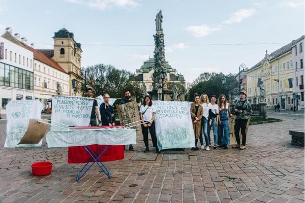 A picture of people staging a form of protest with banners on a square