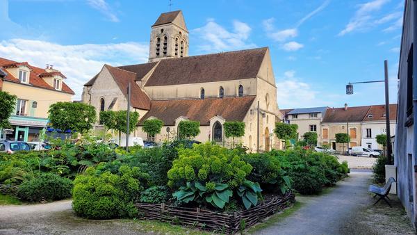 A picture of an idyllic area of a town/city, with a chuch in the background.